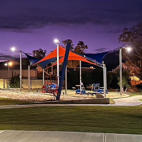 Park lighting illuminating a playground at night