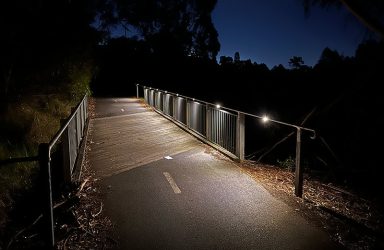 The view at night of the upgraded bridge on the Capital City Trail featuring a custom designed outdoor pathway lighting solution powered by the sun