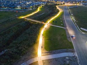 An aerial view of Leadsun's solar pathway lights illuminating the Gables Riparian Corridor at dusk.